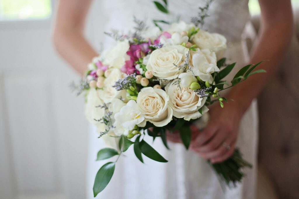 A beautiful bridal bouquet featuring white and pink roses, perfect for a wedding ceremony.