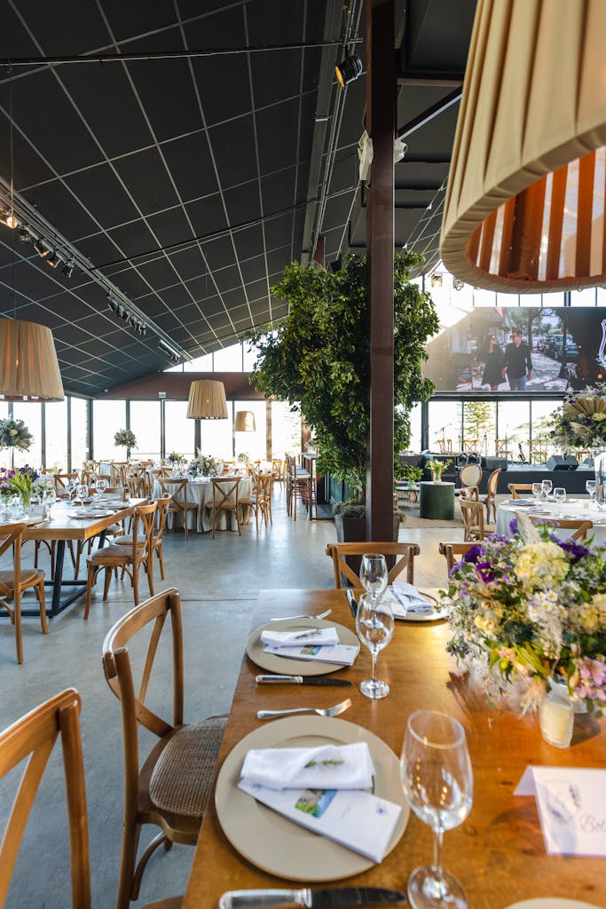 A beautifully decorated wedding reception hall featuring rustic tables and elegant floral arrangements.